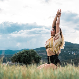 A woman practising yoga outdoors before enjoying tapas after a mindful walk near Altea, Costa Blanca.